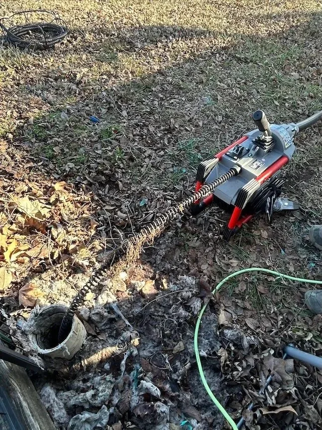 Sectional drain cleaning machine connected to an outdoor PVC cleanout