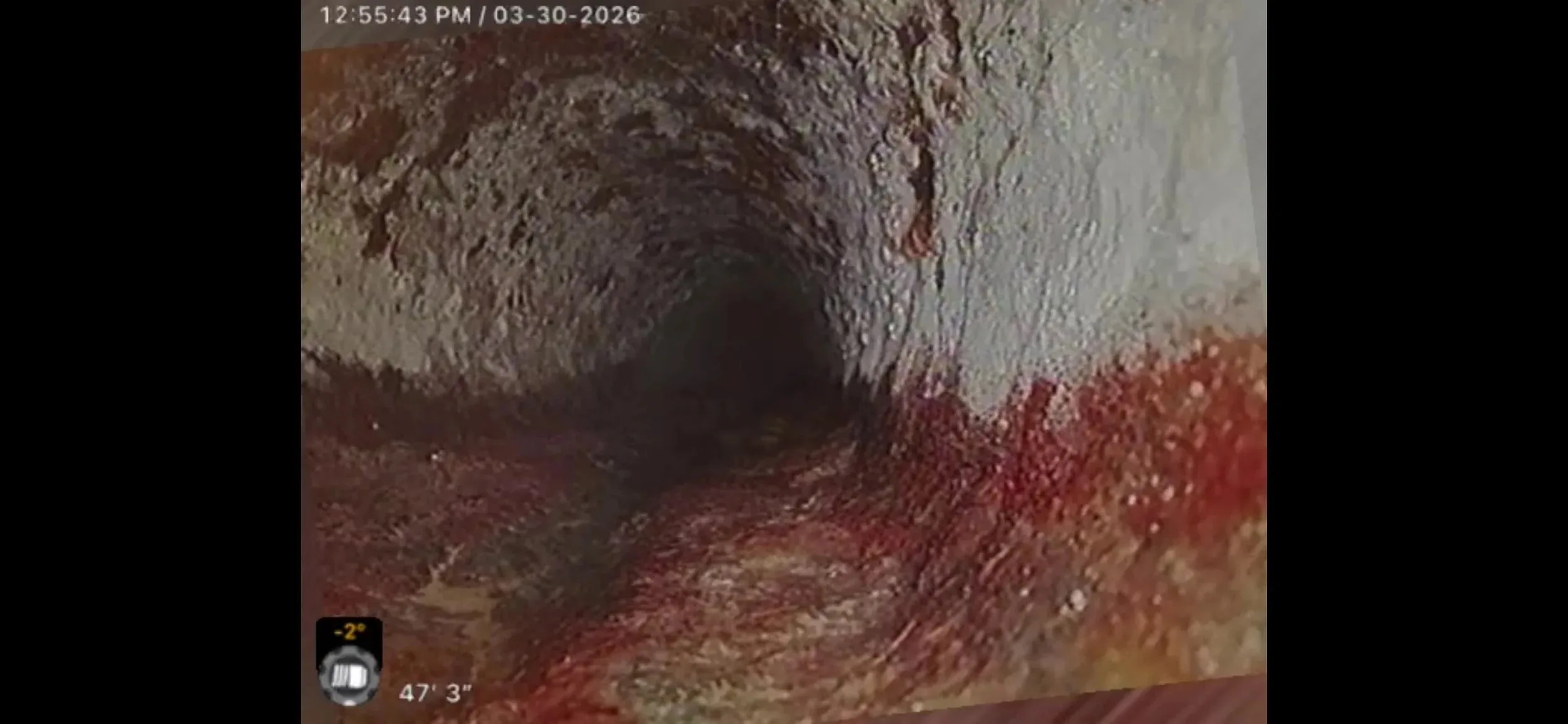 Interior sewer camera view showing buildup along a pipe with distance readout